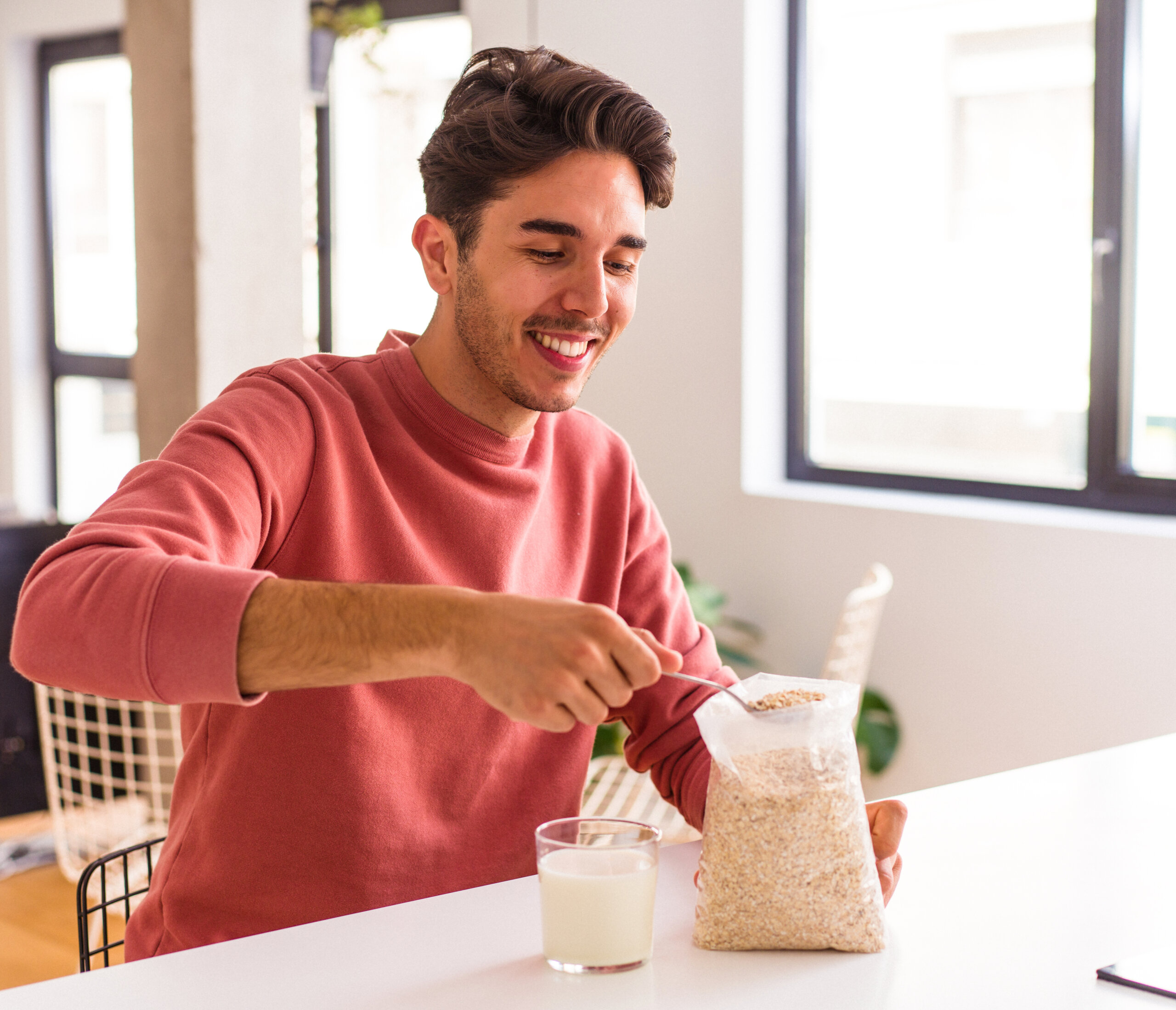 young mixed race man eating oatmeal milk breakfast his kitchen scaled